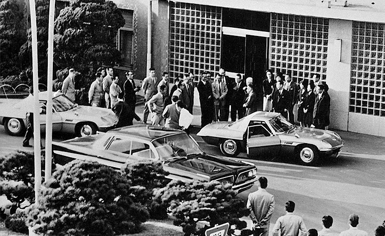 Line of executives and the president of Mazda heading back to the office after making a surprise visit to a show venue in Mazda Cosmo cars (1963)